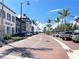 A picturesque town center with brick-paved streets, lined with shops, palm trees, and parked cars at 12728 Richezza Dr, Venice, FL 34293