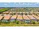 Aerial shot of the home showcasing a tiled roof, screened lanai, backyard landscaping, and community setting at 13873 Karina St, Venice, FL 34293