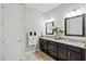 Bright bathroom features double vanities, granite countertops, dark cabinets, and stylish framed mirrors at 13873 Karina St, Venice, FL 34293