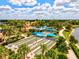 Aerial view of the community's bocce ball courts, with blue shade covers, in a lushly landscaped area at 13873 Karina St, Venice, FL 34293