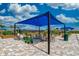A relaxing common area with covered seating, raised garden beds, and a shaded canopy for community gatherings at 13873 Karina St, Venice, FL 34293