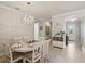 Dining room with elegant lighting fixture, white dining set, and decorative wall paneling at 13873 Karina St, Venice, FL 34293