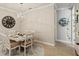 Charming dining area featuring modern lighting, neutral tones, and rustic wood accent wall at 13873 Karina St, Venice, FL 34293
