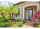 Close-up of a charming front entrance with a glass door, neat landscaping, and a brick walkway at 13873 Karina St, Venice, FL 34293