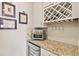 Wet bar features granite countertops, beverage cooler, wine rack, and stylish backsplash at 13873 Karina St, Venice, FL 34293