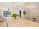Kitchen island with granite countertop, seating, and views of the dining area and outdoor living space at 13873 Karina St, Venice, FL 34293