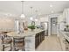 Open kitchen with an island, granite countertops, stainless steel appliances, and a view into the dining area at 13873 Karina St, Venice, FL 34293