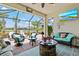 Comfortable screened patio with stylish wicker furniture, a fire pit, and a view of the tranquil waterfront at 13873 Karina St, Venice, FL 34293
