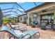 Relaxing screened-in patio area with comfortable seating, a ceiling fan, and an outdoor television at 13873 Karina St, Venice, FL 34293