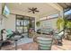 Covered patio boasts wicker furniture, ceiling fan, TV, and a grilling area for outdoor entertaining at 13873 Karina St, Venice, FL 34293