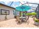 Screened-in lanai with dining set under an umbrella, offering a serene outdoor living space at 13873 Karina St, Venice, FL 34293