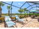Inviting screened-in lanai with lounge chairs, dining area, and a serene view of the waterfront at 13873 Karina St, Venice, FL 34293