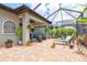 Spacious screened-in lanai with a covered patio, lounge chairs, and lush tropical landscaping at 13873 Karina St, Venice, FL 34293