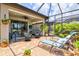 Expansive screened-in patio featuring lounge chairs, a dining area, and lush landscaping for ultimate relaxation at 13873 Karina St, Venice, FL 34293
