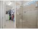 Modern tiled shower features frameless glass doors, accent tiles, a shower seat, and is near the walk-in closet at 13873 Karina St, Venice, FL 34293