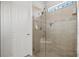 Modern tiled shower features frameless glass doors, accent tiles, a shower seat, and natural light at 13873 Karina St, Venice, FL 34293