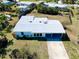 Aerial view of the single Gathering home, flat roof, fenced yard with tropical foliage and long driveway at 140 Poinsettia Ne Cir, Port Charlotte, FL 33952