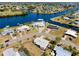 Wide angle aerial view of the home showing canal, neighboring houses, landscaping, and neighborhood at 140 Poinsettia Ne Cir, Port Charlotte, FL 33952