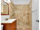 Bathroom featuring a tiled shower with decorative accents and a wood vanity at 140 Poinsettia Ne Cir, Port Charlotte, FL 33952