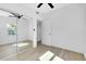 Bedroom with mirrored closet, ceiling fan, light hardwood flooring, and natural light from the window at 140 Poinsettia Ne Cir, Port Charlotte, FL 33952