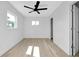 A bedroom featuring a ceiling fan, window and light wood flooring at 140 Poinsettia Ne Cir, Port Charlotte, FL 33952
