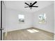 Bright bedroom with neutral walls and floors, ceiling fan and two windows at 140 Poinsettia Ne Cir, Port Charlotte, FL 33952