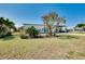 Exterior front view of the charming home showing lush landscaping and carport area at 140 Poinsettia Ne Cir, Port Charlotte, FL 33952
