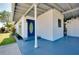 Inviting blue front door and covered porch welcome you to this charming home at 140 Poinsettia Ne Cir, Port Charlotte, FL 33952