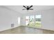 Bright living room with large windows, modern floors, and a sleek ceiling fan at 140 Poinsettia Ne Cir, Port Charlotte, FL 33952