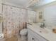 This bathroom features a single sink, tiled floors and a shower with a seashell themed curtain at 143 Braemar Ave, Venice, FL 34293