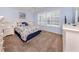 Cozy bedroom with blue walls, nautical-themed bedding, and a large window at 143 Braemar Ave, Venice, FL 34293