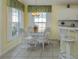 Bright breakfast nook with white wicker furniture set and views from large windows at 143 Braemar Ave, Venice, FL 34293