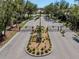 This is a street view of the gated entrance to a community with mature trees and landscaping at 143 Braemar Ave, Venice, FL 34293