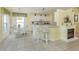 Bright kitchen with white cabinetry and eat-in breakfast bar, with living room access at 143 Braemar Ave, Venice, FL 34293