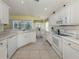 Open kitchen with white cabinetry, appliances, and an adjacent breakfast nook with lots of natural light at 143 Braemar Ave, Venice, FL 34293