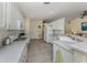 Spacious kitchen with white cabinets, appliances, breakfast bar, and tile flooring at 143 Braemar Ave, Venice, FL 34293