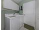 This laundry room features white cabinetry above a washer and dryer set at 143 Braemar Ave, Venice, FL 34293