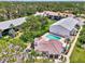 Aerial view of condo complex featuring a pool, lush landscaping, and convenient parking areas at 1730 Manasota Beach Rd # 215, Englewood, FL 34223