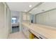 Well-lit bathroom with a large mirror, marble counter, and access to bedroom at 1730 Manasota Beach Rd # 215, Englewood, FL 34223