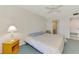 Bright bedroom featuring a ceiling fan and natural light with bedside table at 1730 Manasota Beach Rd # 215, Englewood, FL 34223