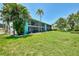 Well-manicured lawn and mature trees frame the exterior of this two-story condo building at 1730 Manasota Beach Rd # 215, Englewood, FL 34223