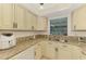 Charming kitchen featuring granite countertops and cream colored cabinets at 1730 Manasota Beach Rd # 215, Englewood, FL 34223