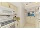 Traditional kitchen with cream colored cabinetry, granite countertops, and white appliances at 1730 Manasota Beach Rd # 215, Englewood, FL 34223