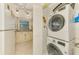 Laundry room featuring modern stacked washer and dryer next to an eat-in kitchen at 1730 Manasota Beach Rd # 215, Englewood, FL 34223