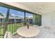 Relaxing screened porch with table and chairs overlooking landscaped green area at 1730 Manasota Beach Rd # 215, Englewood, FL 34223