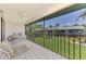 Enjoy the screened porch with a fan, table, chairs, and views of the green space at 1730 Manasota Beach Rd # 215, Englewood, FL 34223