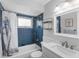 Bathroom featuring blue tiled walls, a shower-tub combo, and vanity with stainless fixtures at 18302 Burkholder Cir, Port Charlotte, FL 33948