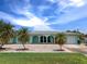 Inviting home with a light blue exterior, well-kept lawn, and lovely landscaping at 18302 Burkholder Cir, Port Charlotte, FL 33948