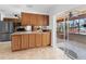 This kitchen has bright wood cabinets with a stainless steel refrigerator and access to the lanai at 18302 Burkholder Cir, Port Charlotte, FL 33948