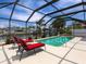 Screened pool area featuring outdoor lounge seating and a waterfront view at 18302 Burkholder Cir, Port Charlotte, FL 33948